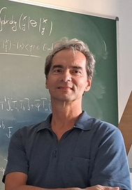 Portrait of Harold Steinacker standing in front of a blackboard with formulas